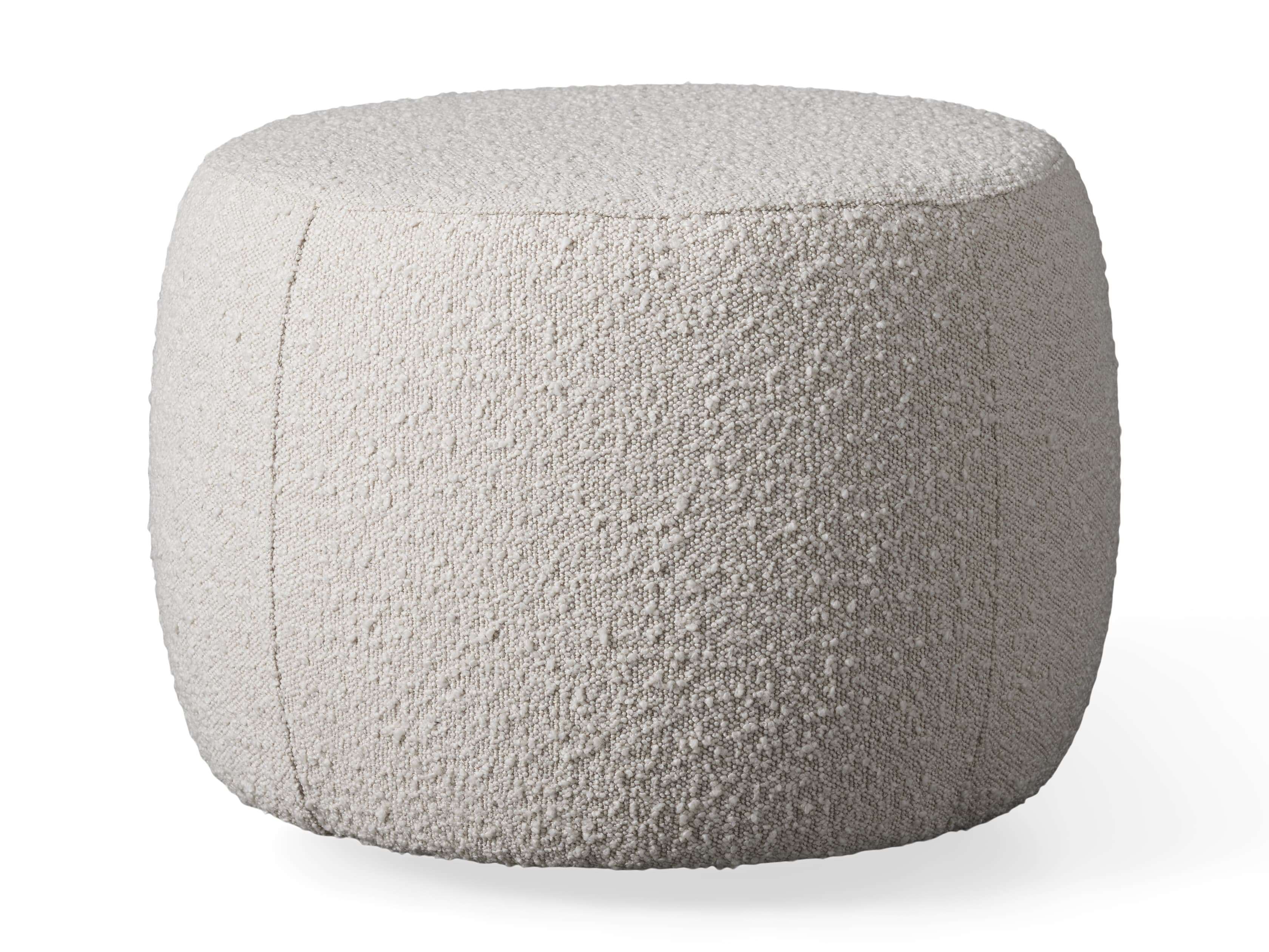 A natural upholstered ottoman with a textured surface and rounded edges, styled as part of the Ryles Collection by Arhaus.