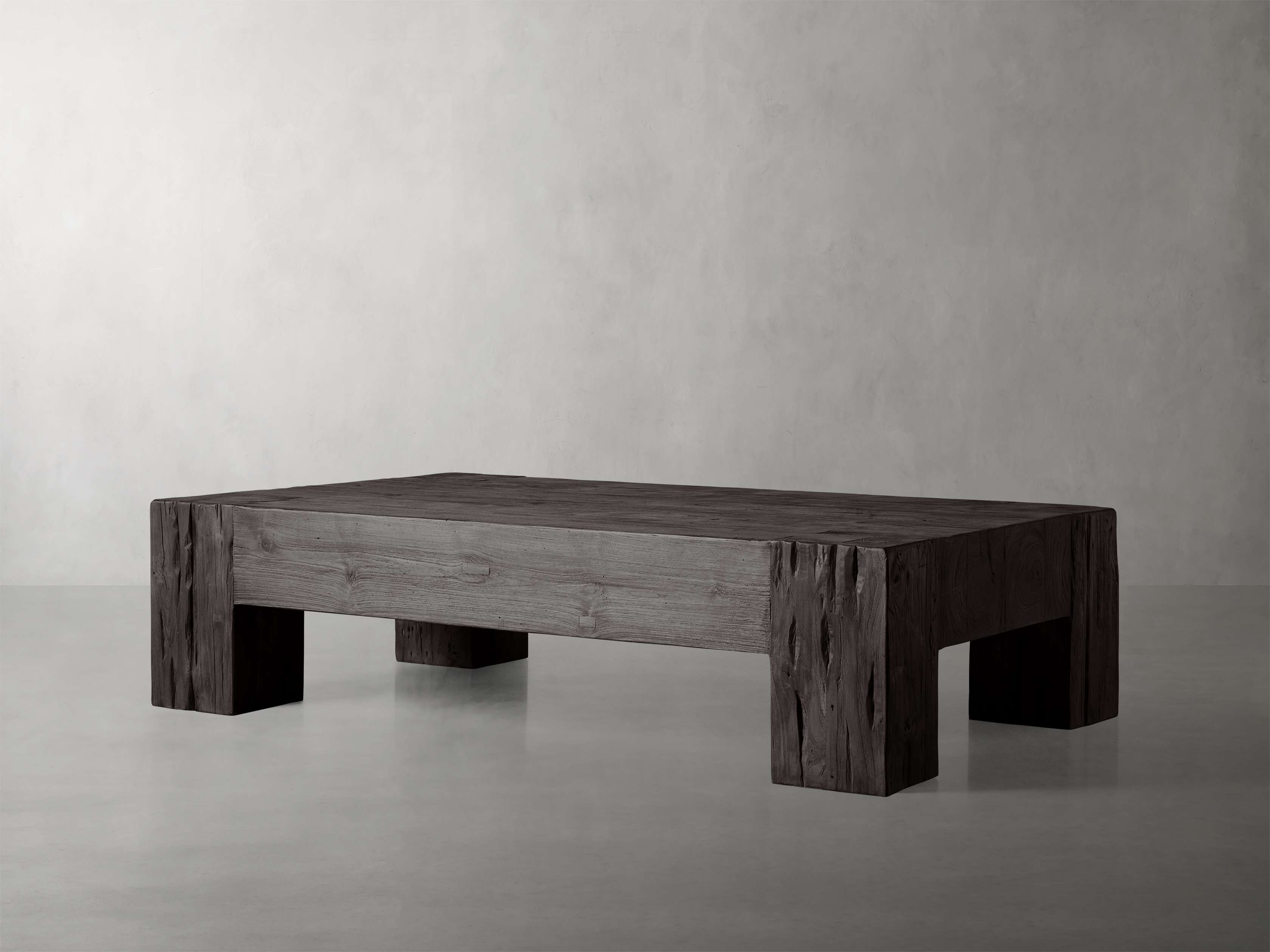 A gray wooden coffee table made from reclaimed teak wood, featuring a rectangular design with solid, thick legs and a rustic finish.
