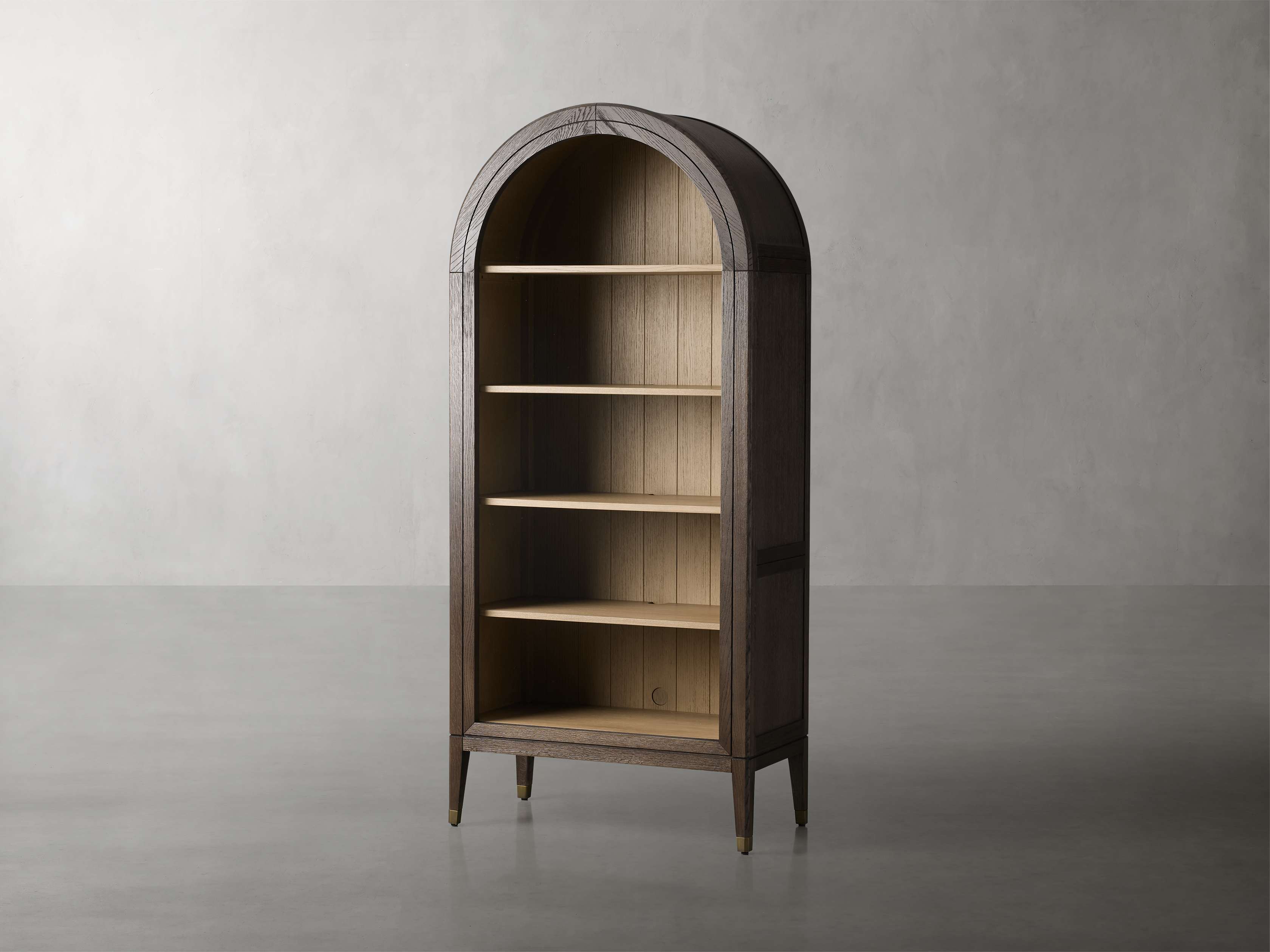 A wooden bookcase with a curved top, open shelves, and tapered legs, showcasing natural oak graining against a neutral background.