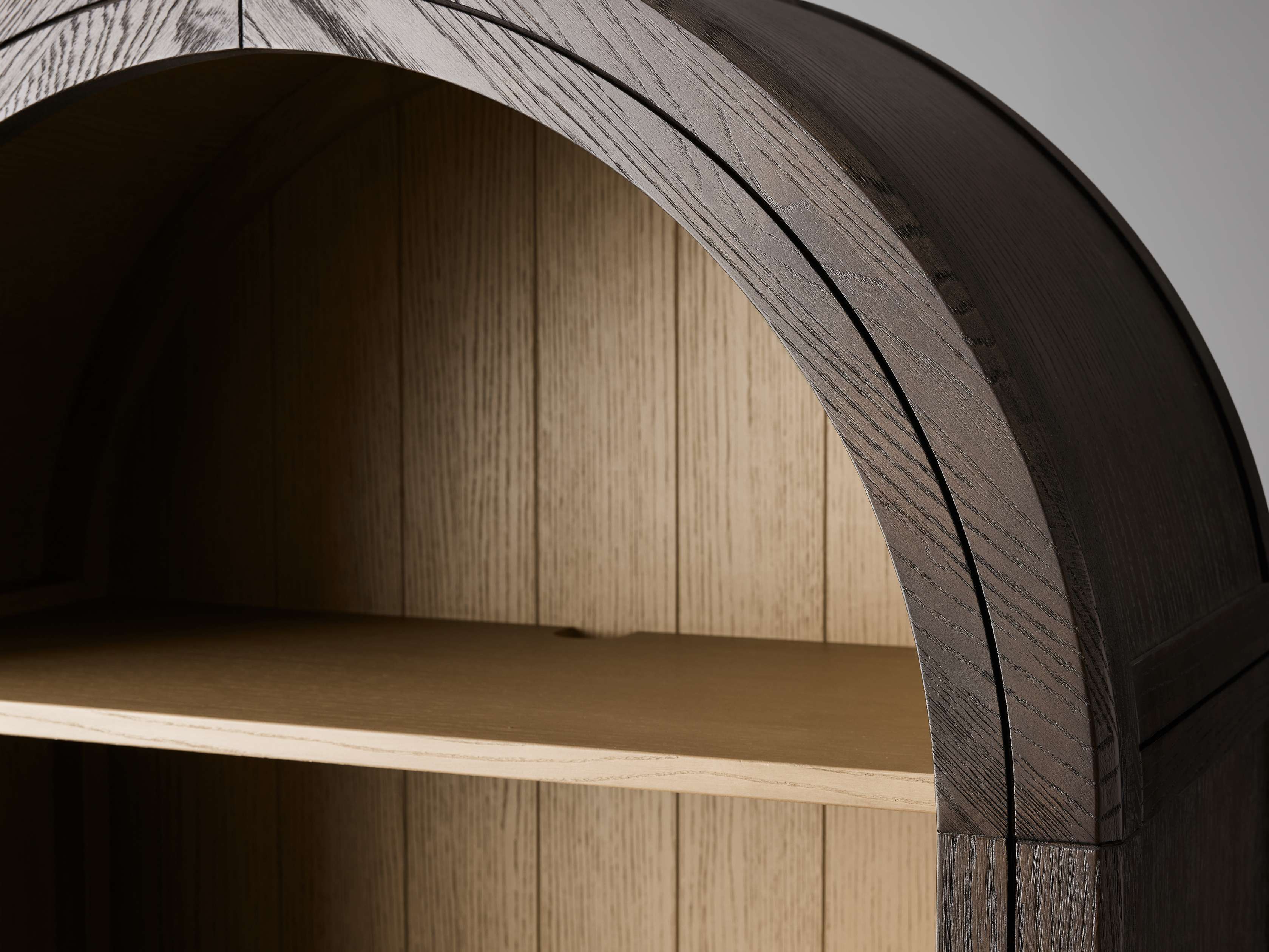 Close-up view of the Hattie Open Bookcase showcasing its curved wooden frame, natural oak finish, and spacious shelf.