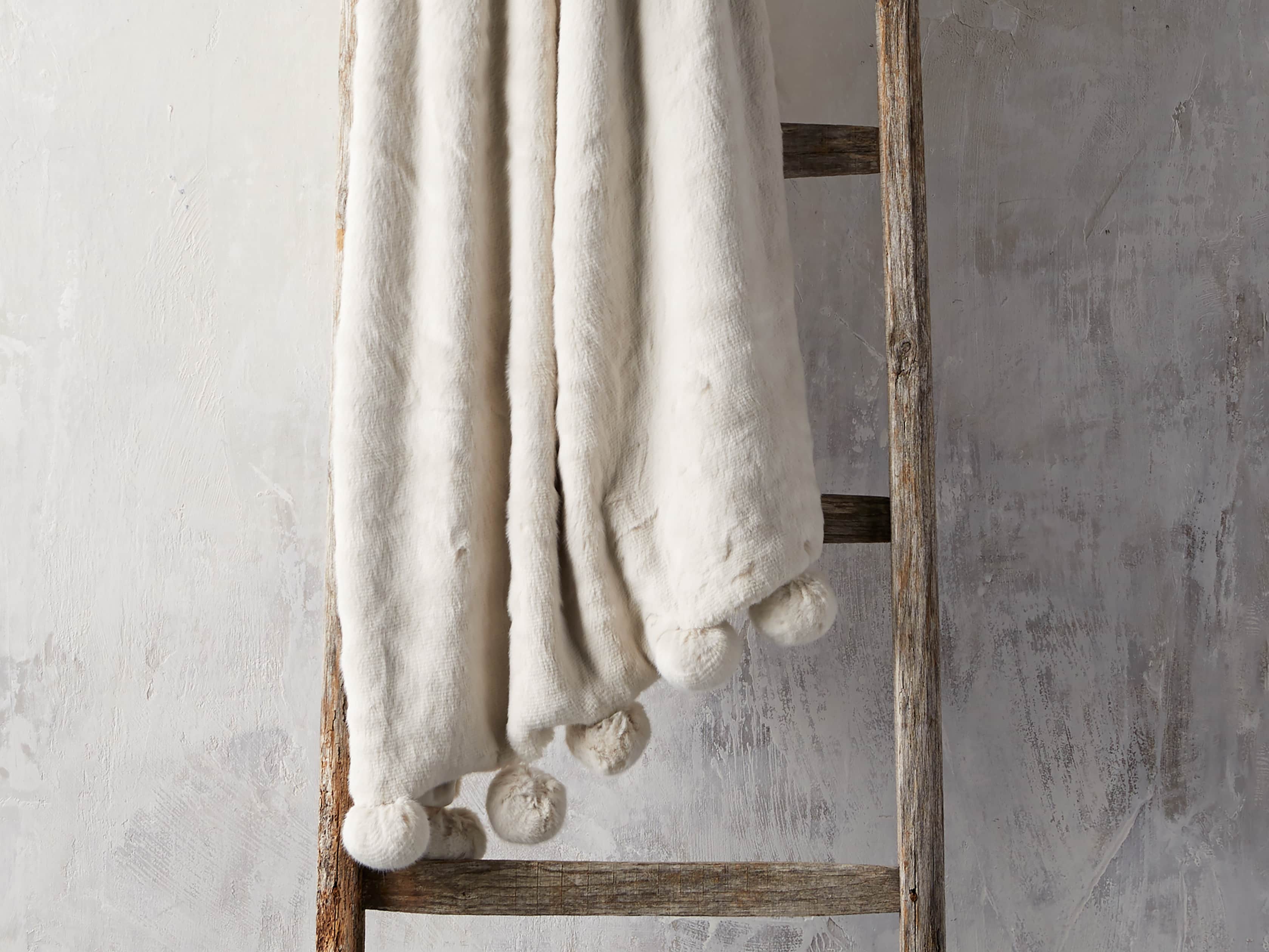 Faux Fur Pom Throw in Ivory - Charming white home exteriors as well as neutral decor finds at Arhaus.