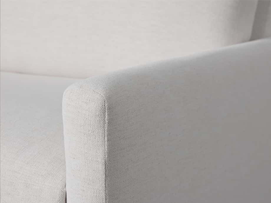 Close-up of the Kipton Sofa's light beige fabric and armrest, showcasing the textured material and sleek, modern design.