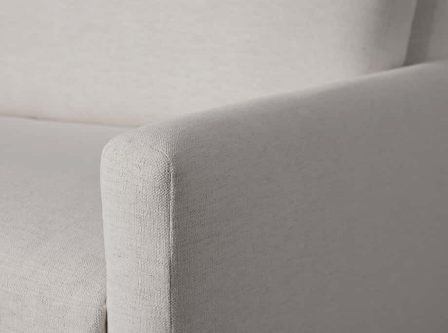 Close-up view of the Kipton Sofa showing the textured light beige fabric, cushioned armrest, and backrest, highlighting craftsmanship.