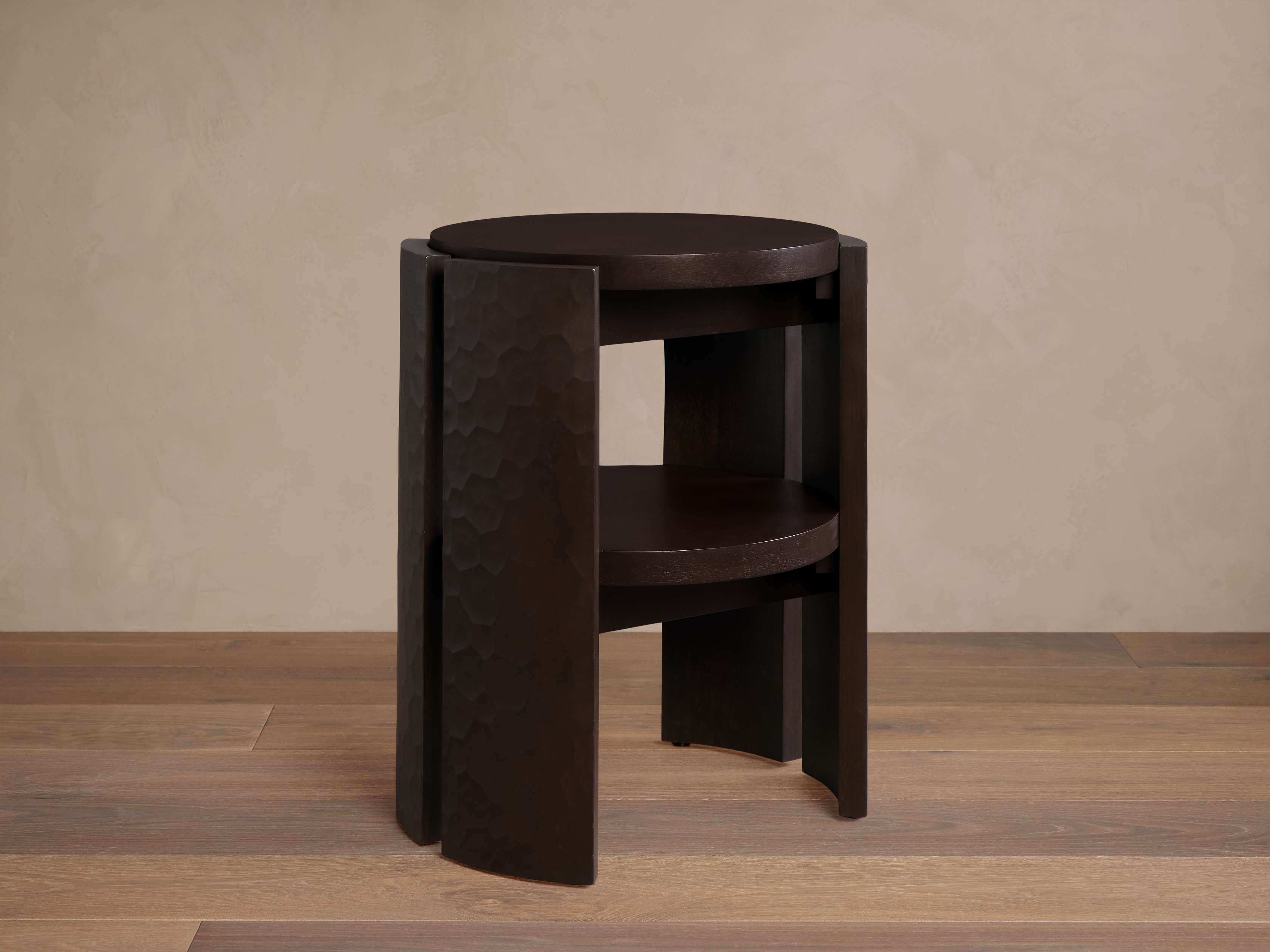 Angle view of the table showing hammered texture on the side panels and two-tier shelves.