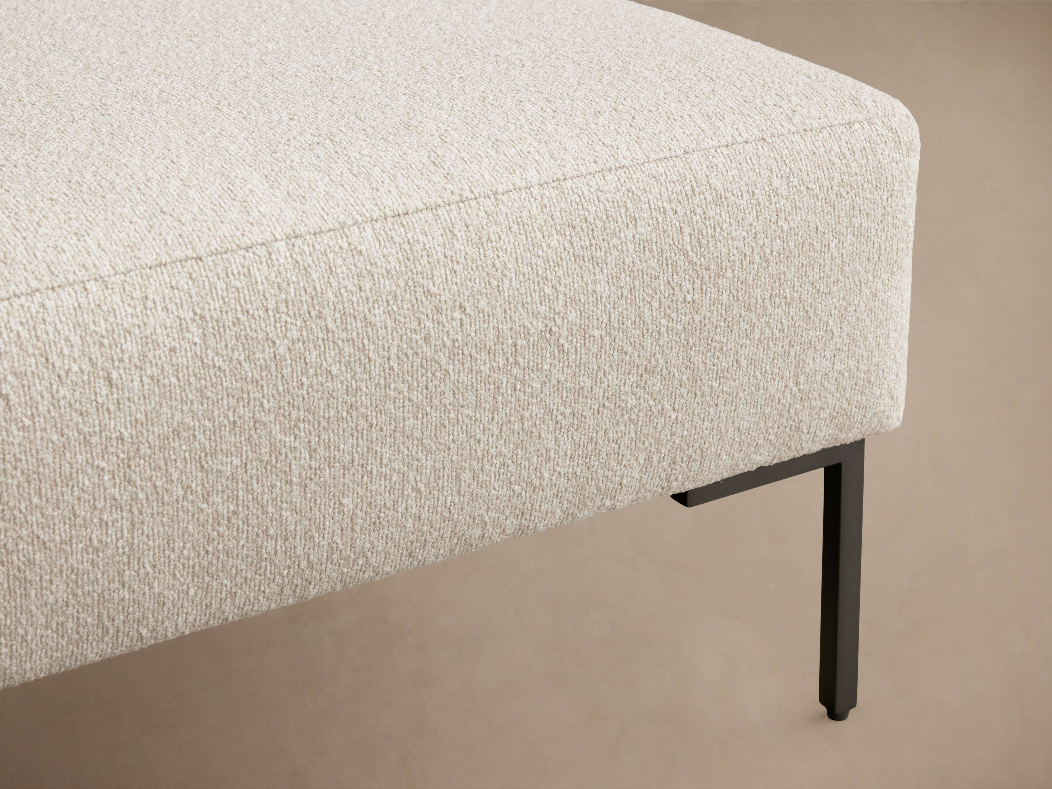 A close-up of the upholstery on a beige bench