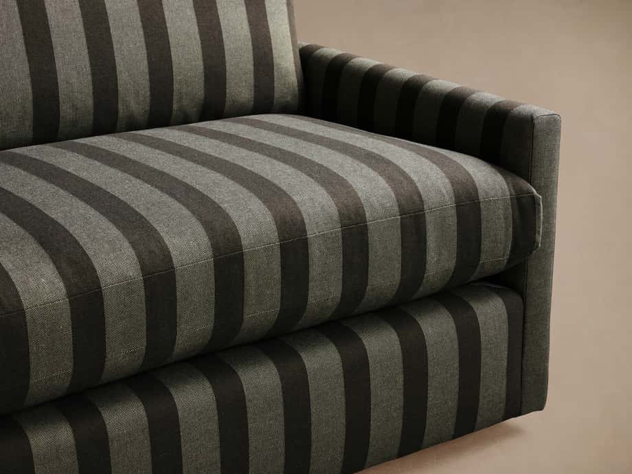 Kipton Slim Arm Sofa. Close-up shows right arm, seat, and back with dark and light grey vertical and horizontal striped upholstery.