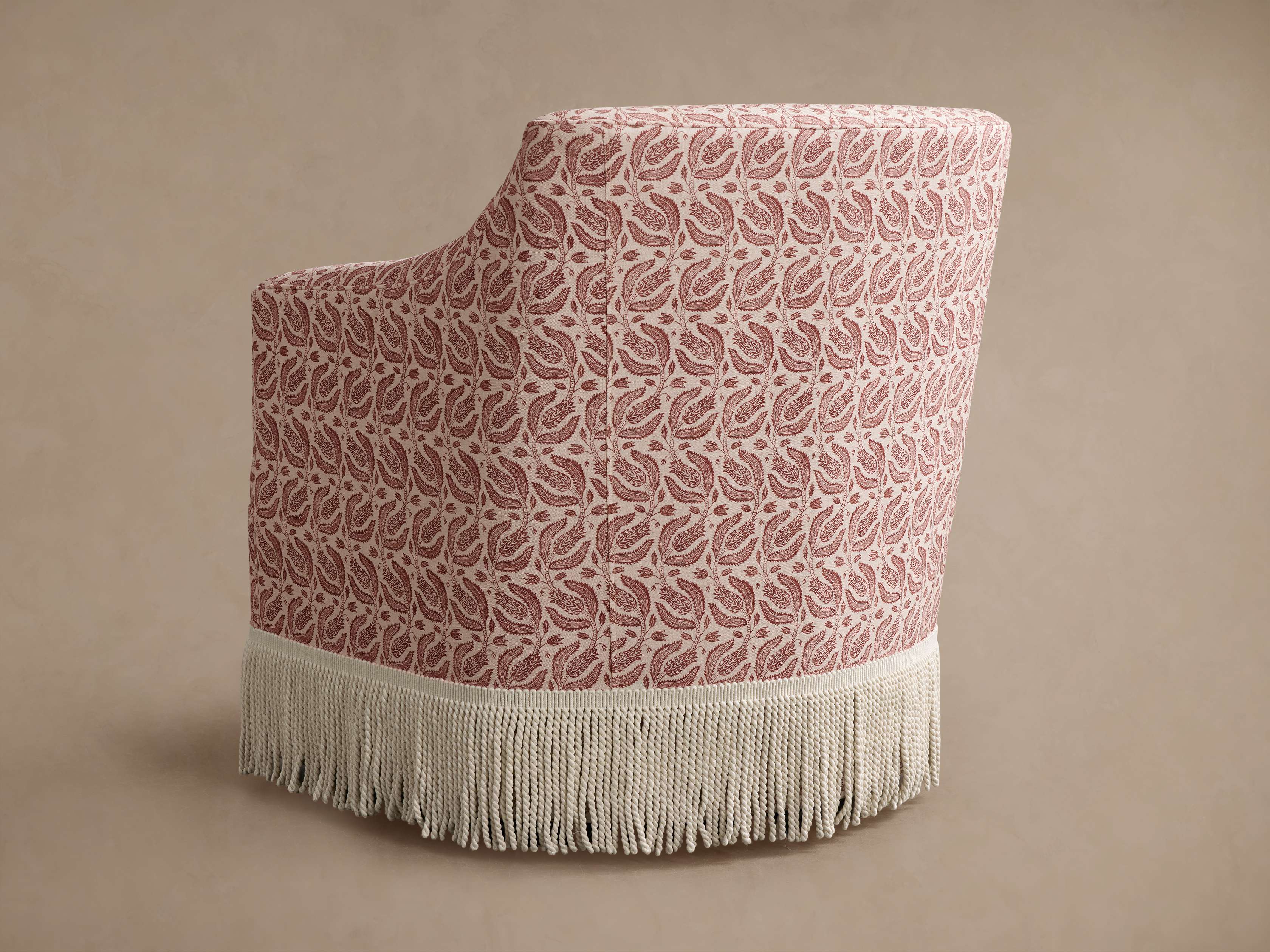 Chair with pink and white paisley fabric and white fringe from side